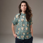 All Above Boutique women's loose-fit rayon shirt with short sleeves, floral print in teal, cream, and black, and an asymmetric hem.