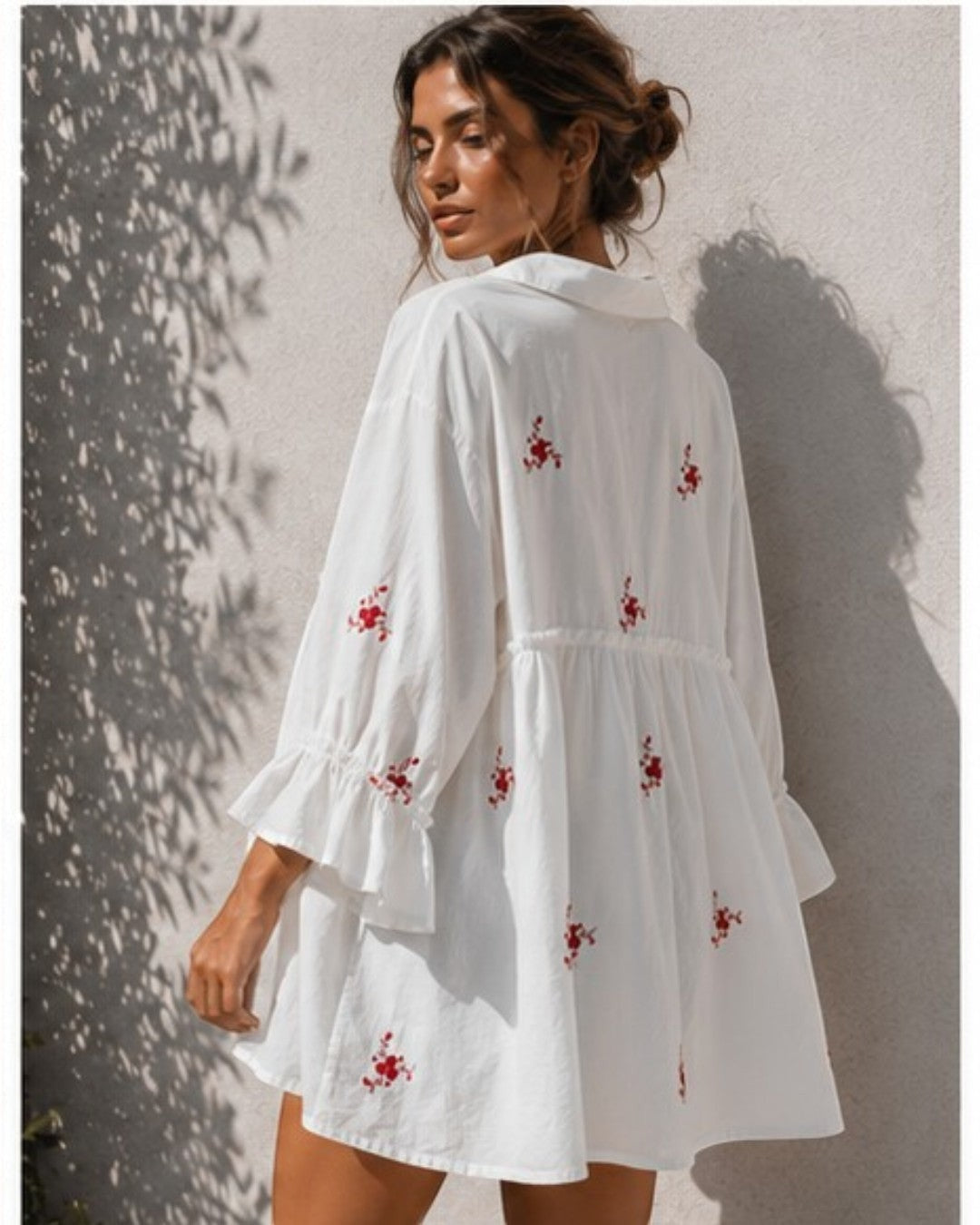 All Above Boutique white oversized shirt dress with red floral embroidery and ruffled 3/4 sleeves.