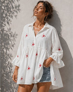All Above Boutique white oversized tunic shirt with red floral embroidery and ruffled 3/4 sleeves.