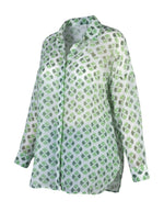 All Above Boutique white rayon shirt with green clover print, classic collar, long sleeves, and asymmetric hem.
