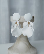 All Above Boutique white matte metal petal drop earrings with geometric base. Elegant, dynamic, and lightweight statement earrings.