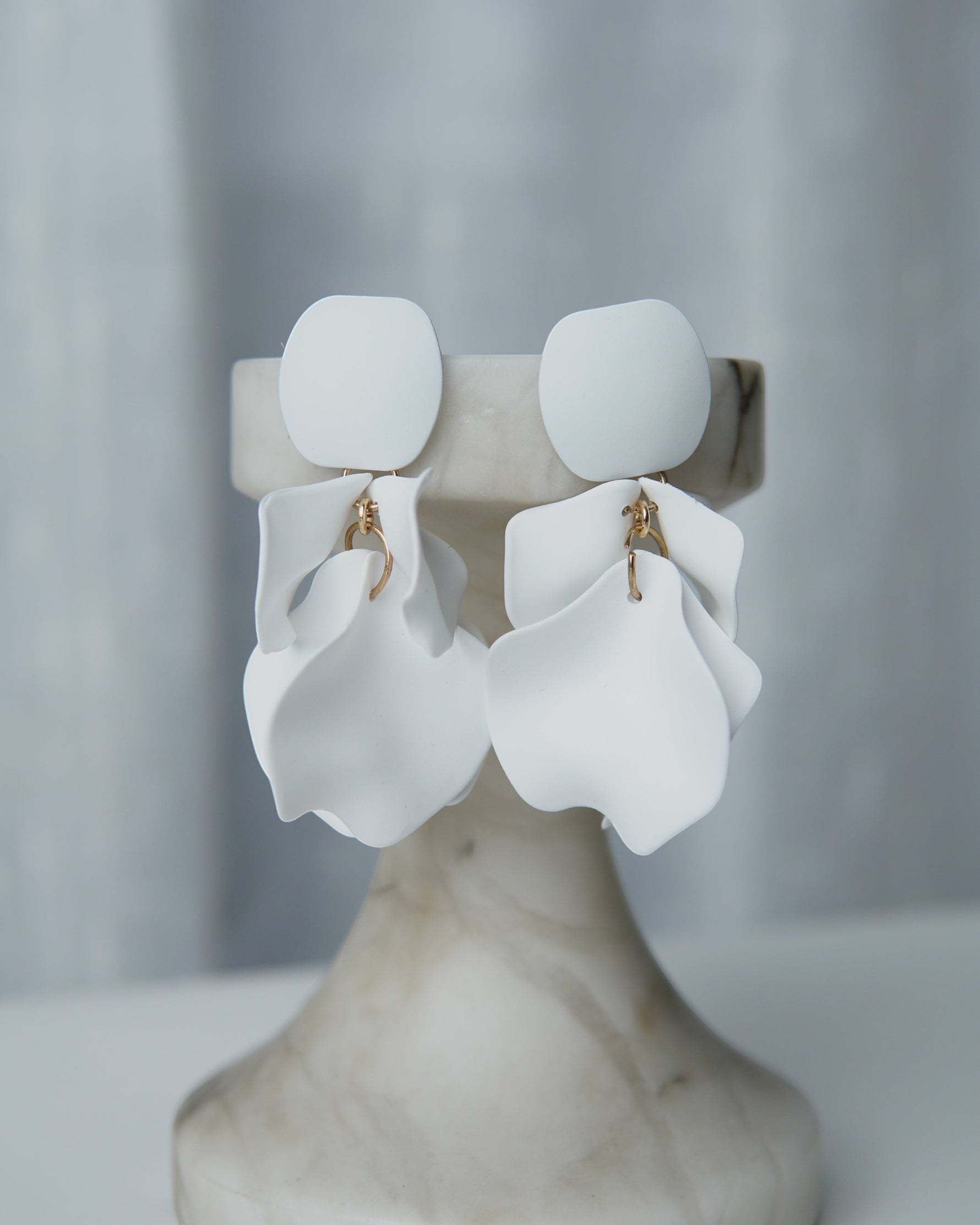 All Above Boutique white matte metal petal drop earrings with geometric base. Elegant, dynamic, and lightweight statement earrings.