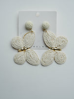 All Above Boutique white raffia butterfly statement earrings with gold accents. Boho chic style.