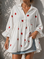 All Above Boutique white oversized cotton shirt with red strawberry print, ruffled 3/4 sleeves, and tiered hem. Model wears denim shorts.