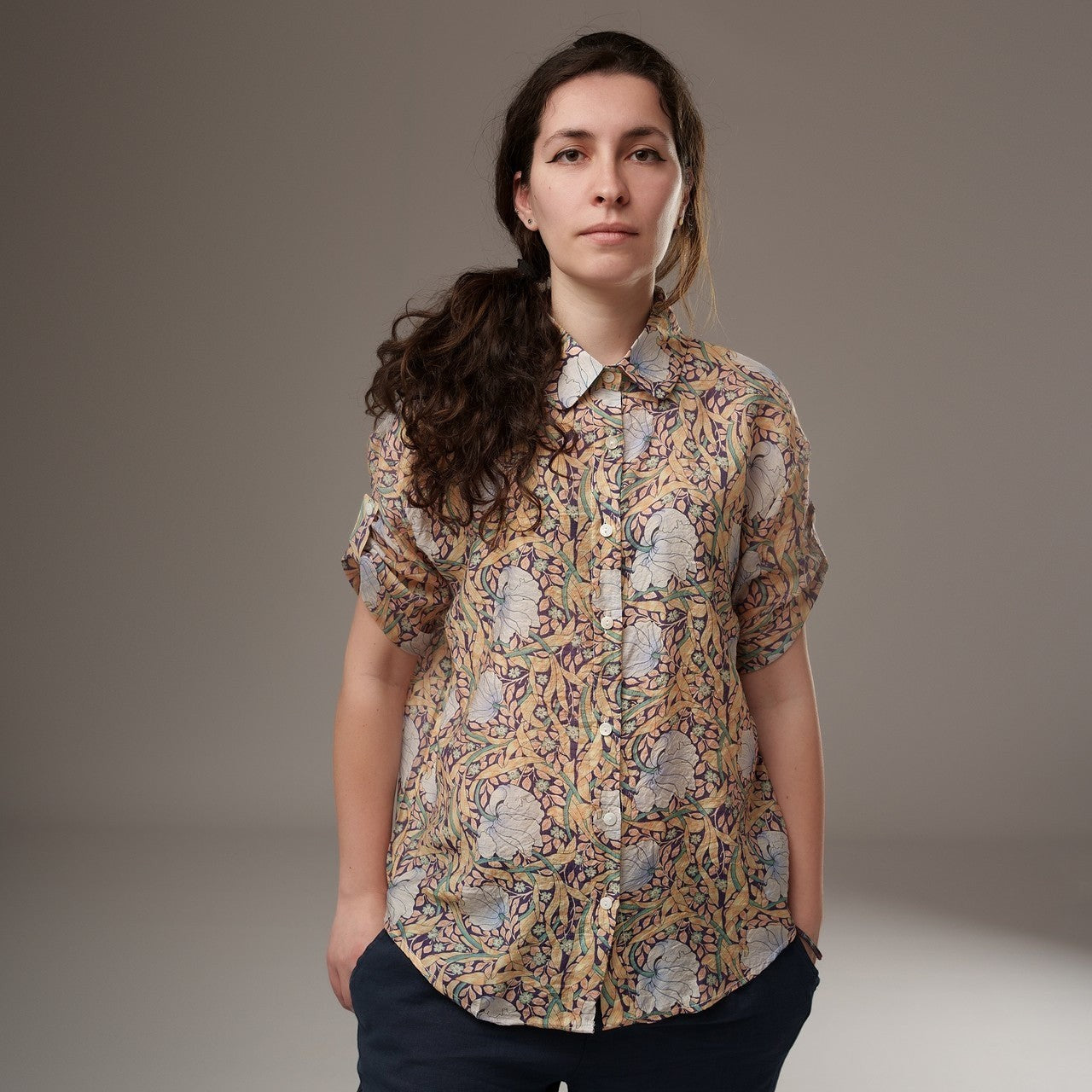All Above Boutique women's loose-fit rayon floral print shirt with short sleeves and an asymmetric hem in yellow and blue.