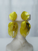 All Above Boutique yellow statement earrings with layered petal design and iridescent finish.