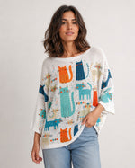 Bluză albă oversize cu imprimeu pisici colorate, purtată de model din unghi trei sferturi. All Above Boutique.