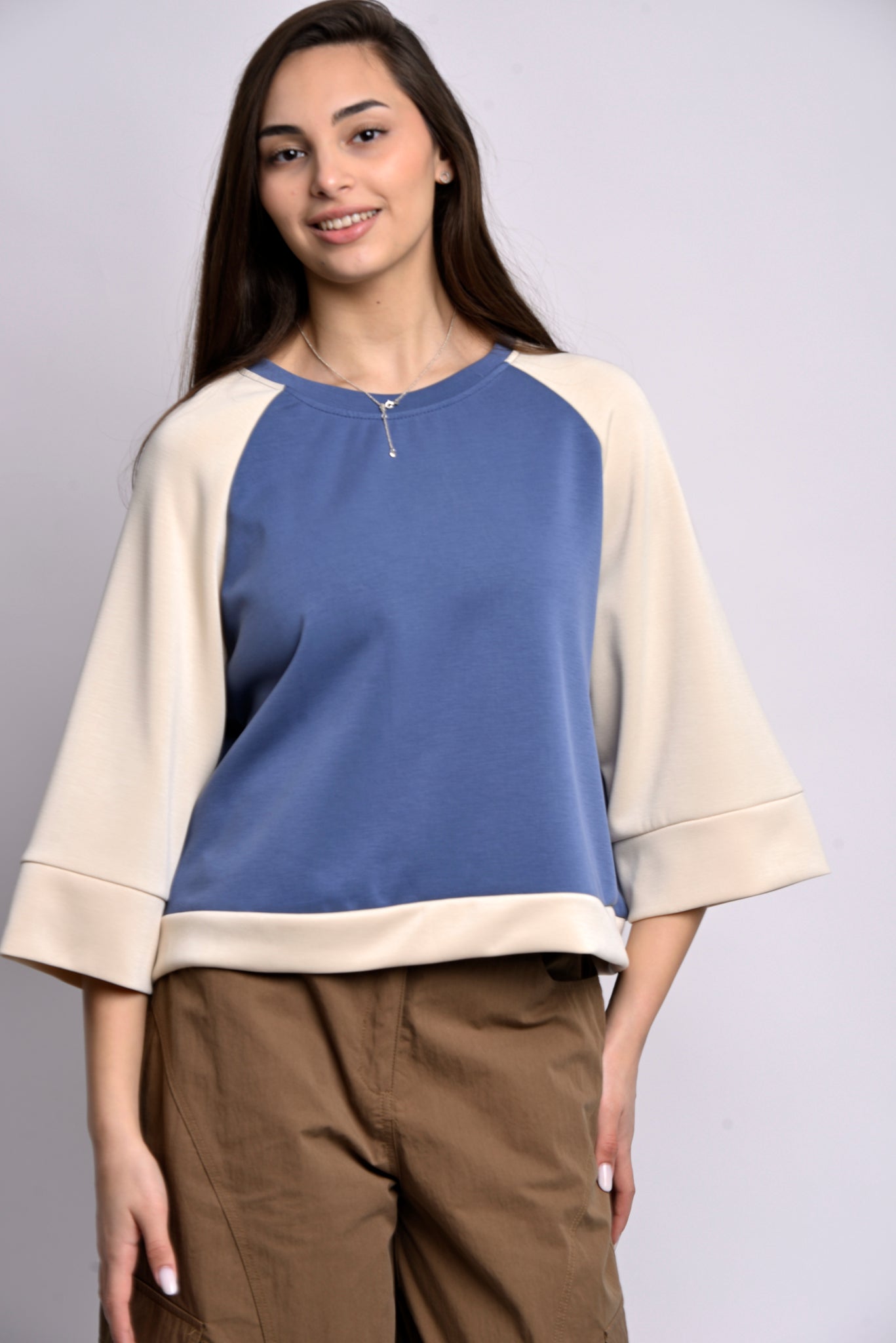 Bluză oversize bicolor albastru cu bej, mânecă raglan, purtată de model