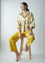 Cămașă tip bluză cu print floral galben purtată pe model, vedere frontală
