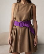 Curea lată violet pentru damă, purtată în talie peste rochie, cu design petrecut și nod decorativ.