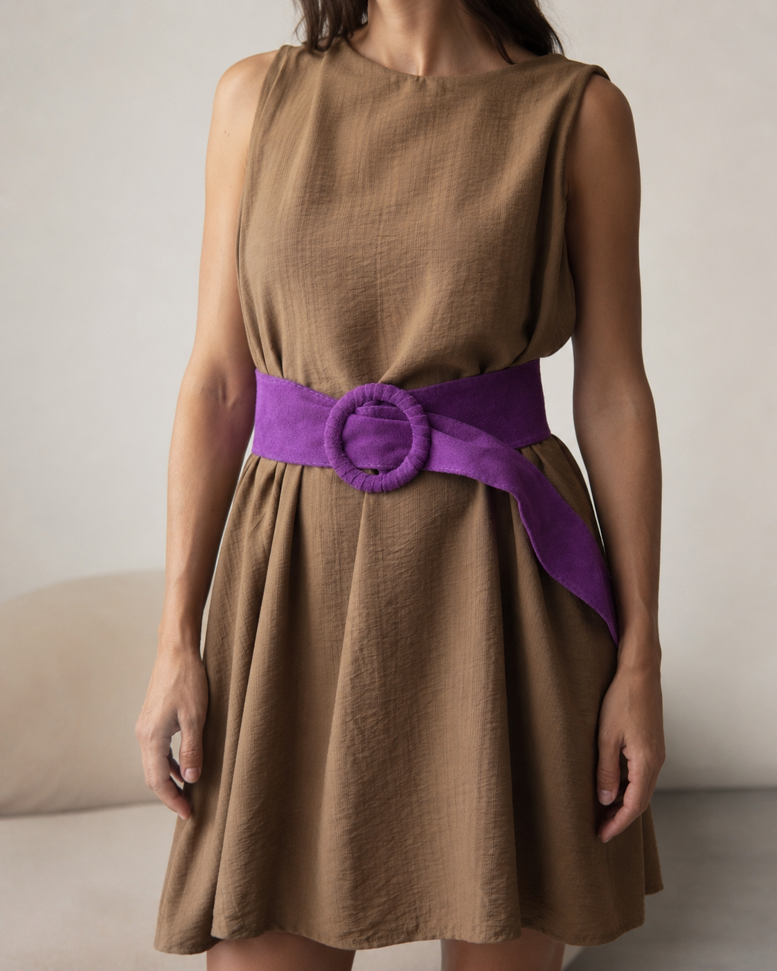Curea lată violet pentru damă, purtată în talie peste rochie, cu design petrecut și nod decorativ.
