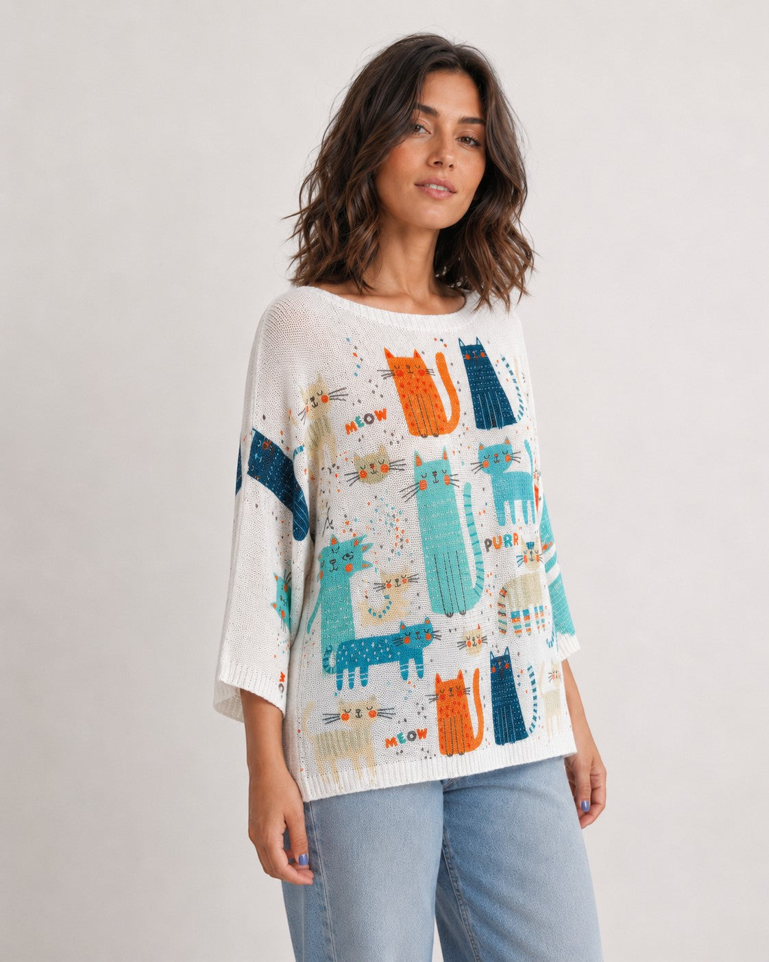 Detaliu bluză albă din tricot cu imprimeu multicolor cu pisici purtată de model. All Above Boutique.