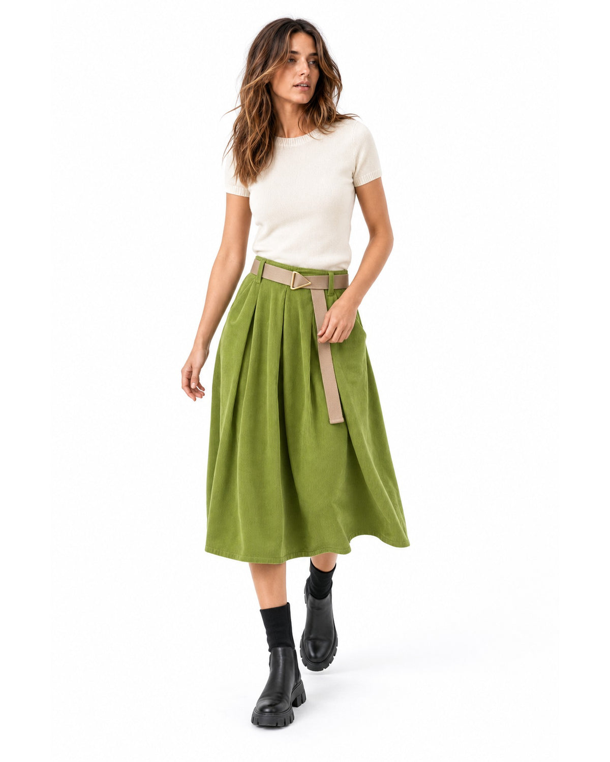 Fustă midi din catifea reiată verde fistic, evazată, cu curea bej, purtată pe model în mers - All Above Boutique