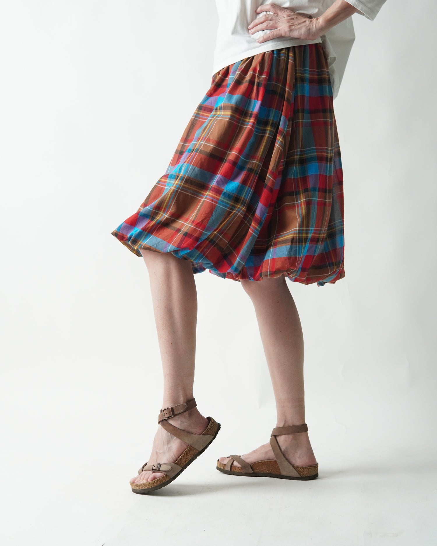 Fustă scurtă gogoșar în carouri, purtată în mișcare, cu volum amplu