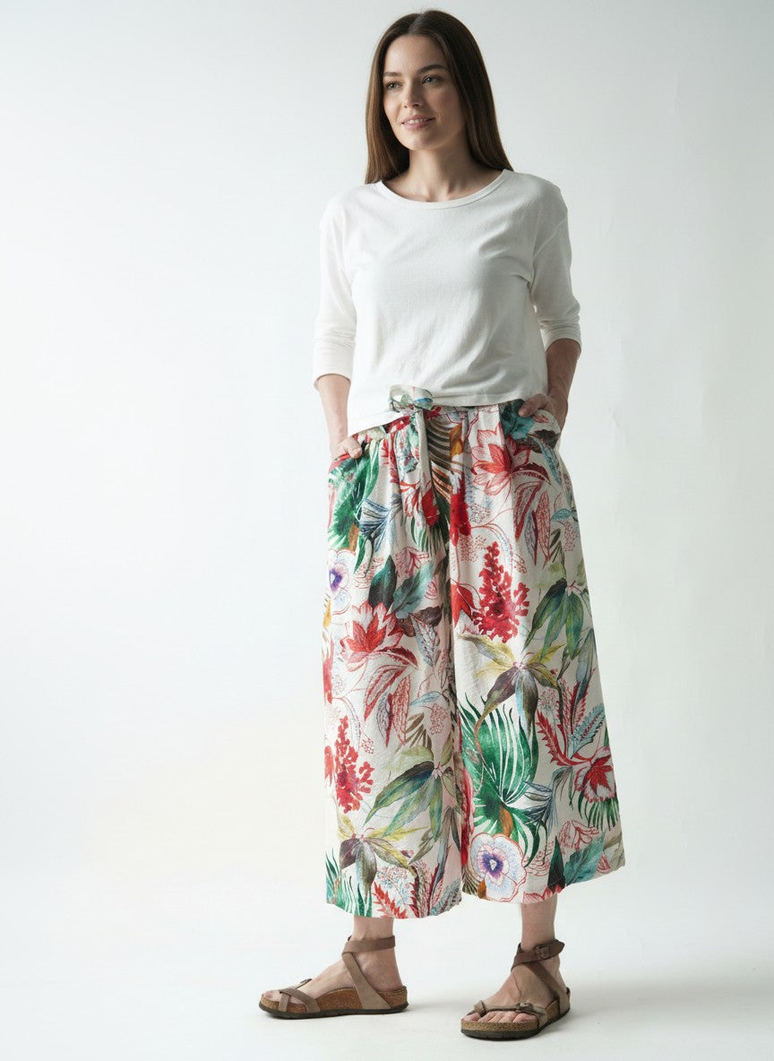 Pantaloni culotte fluizi cu print floral pe fundal alb purtați pe model