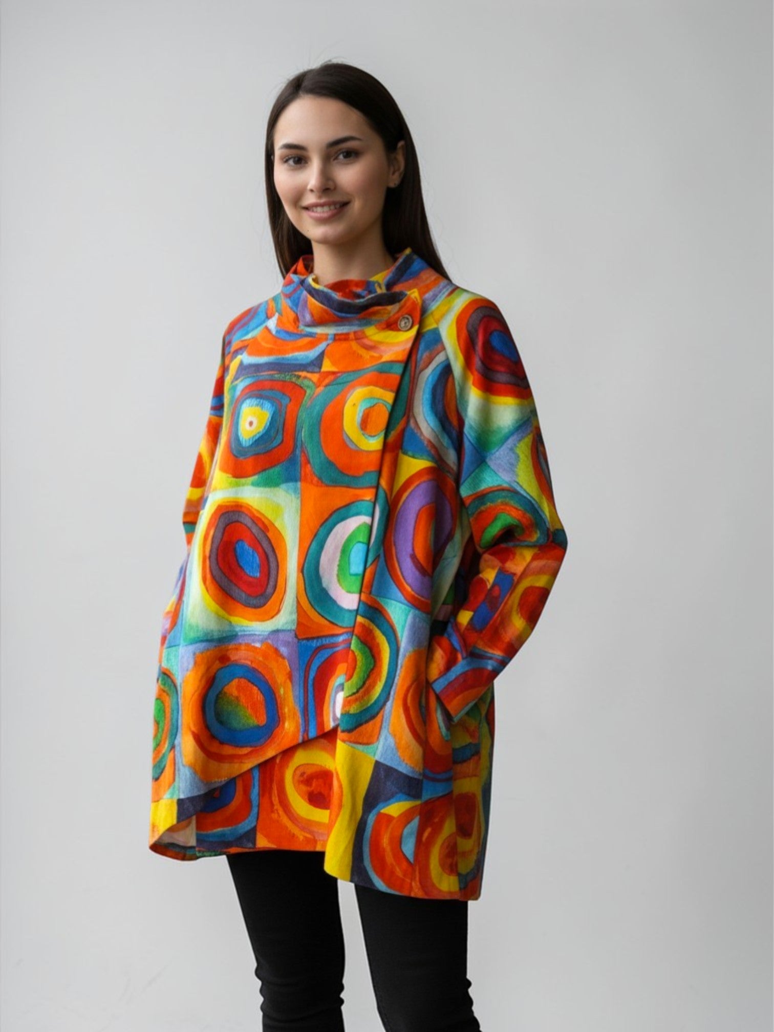 Model purtând jachetă damă cu imprimeu geometric multicolor cu cercuri concentrice, croială asimetrică și guler înalt