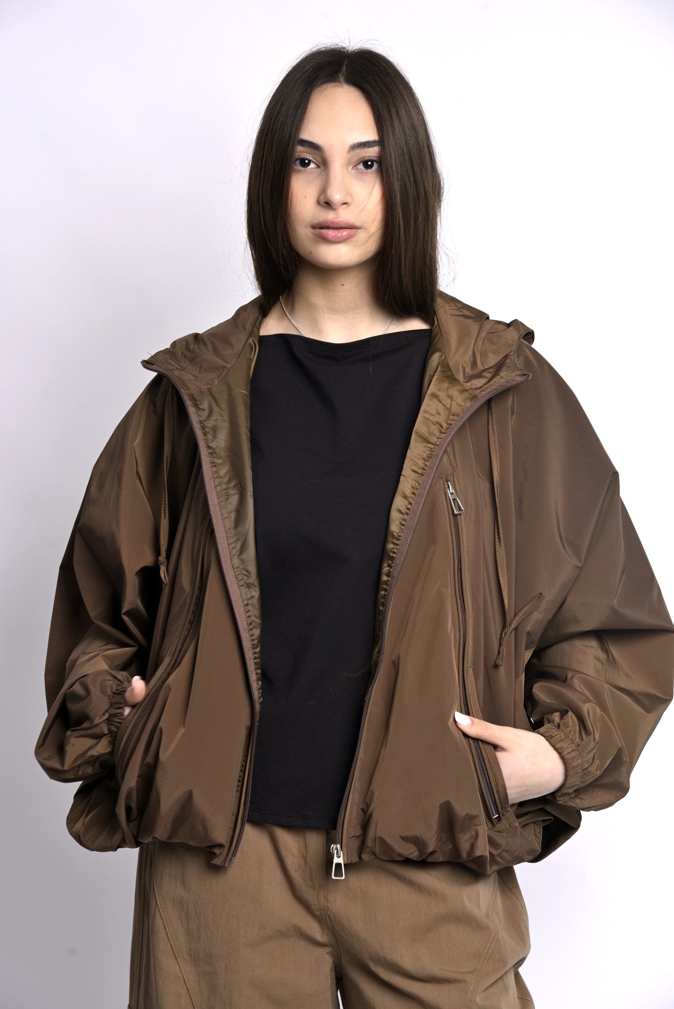 Jachetă impermeabilă maro purtată deschis, stil casual