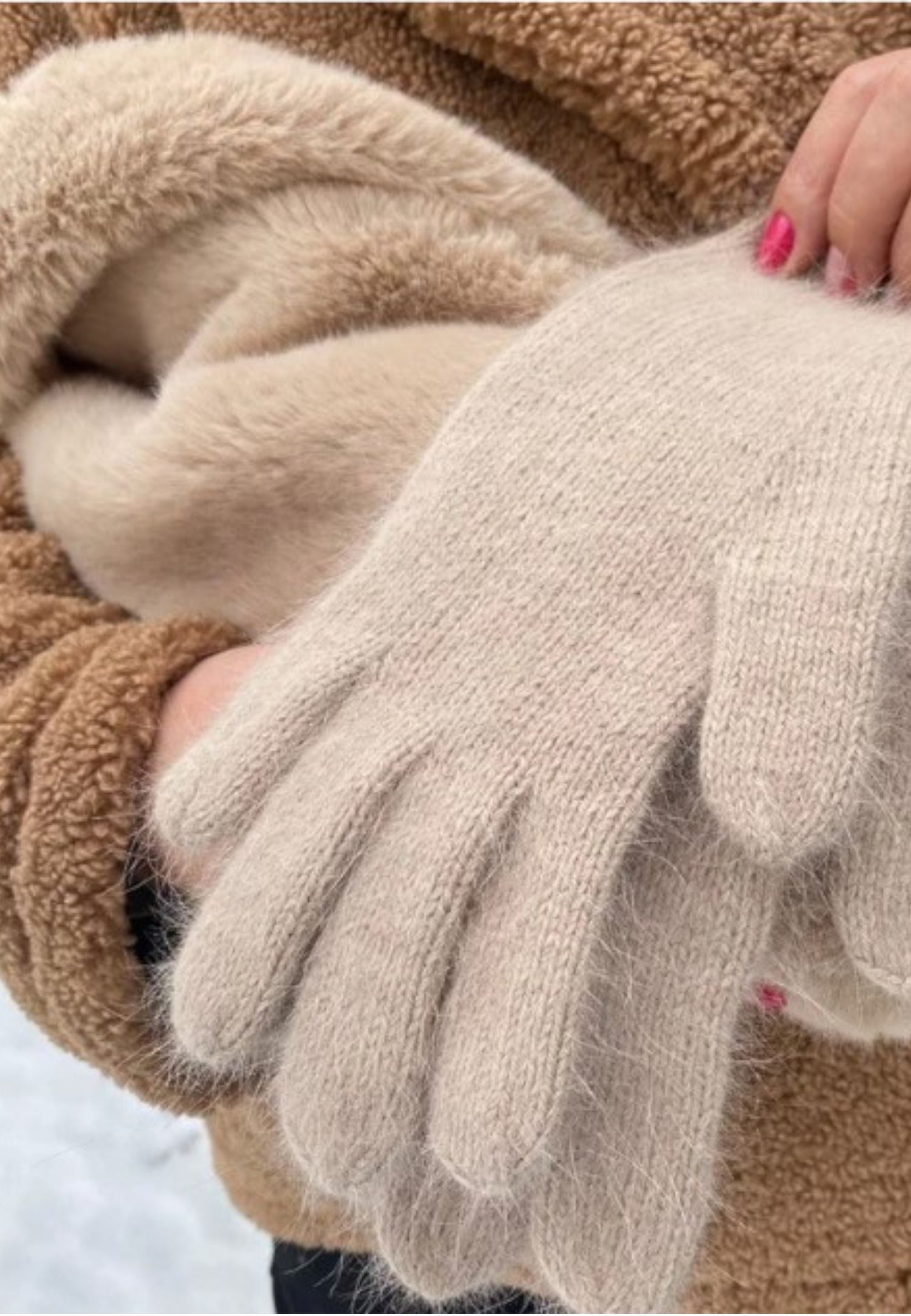 Mănuși pufoase bej din mohair în combinație cu un palton crem și o geantă maro elegantă.