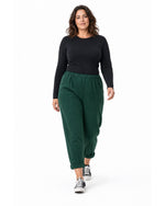 Pantaloni conici de trening verde închis plus size, model în mers - All Above Boutique