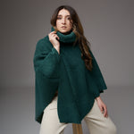 Poncho verde plușat pentru femei, cu guler înalt, purtat de un model de 175 cm și 52 kg, design lejer și călduros, ideal pentru sezonul rece.