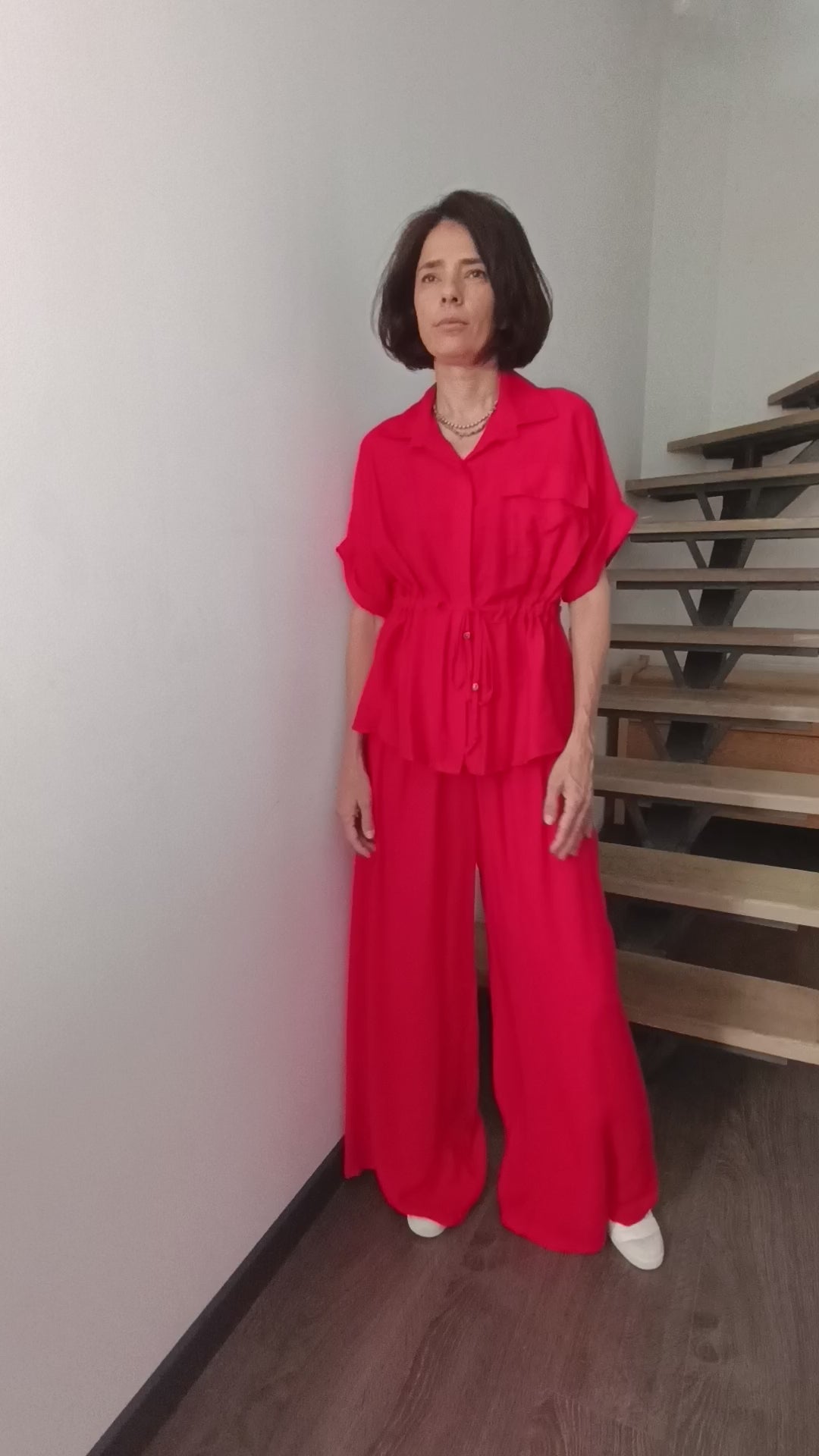 Compleu roșu deschis din material satinat, cu bluză ajustabilă în talie și pantaloni palazzo