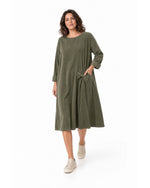 Rochie midi din catifea reiată kaki, largă, cu fundă laterală, purtată pe model în mers - All Above Boutique