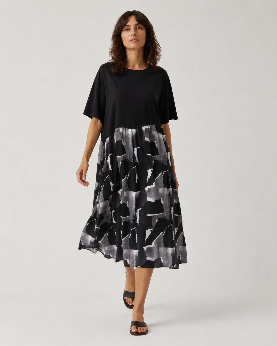 Rochie midi neagră cu print abstract gri, croi lejer, prezentată pe model în mers