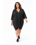Rochie neagră cocon pentru mărimi mari, în mers, purtată cu teniși negri - All Above Boutique