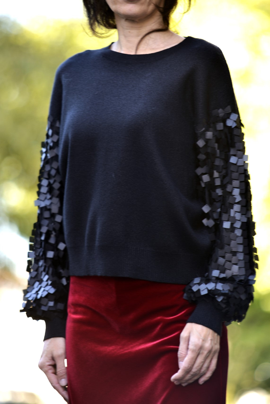 Pulover negru chic, detalii de paiete lucioase și material confortabil.