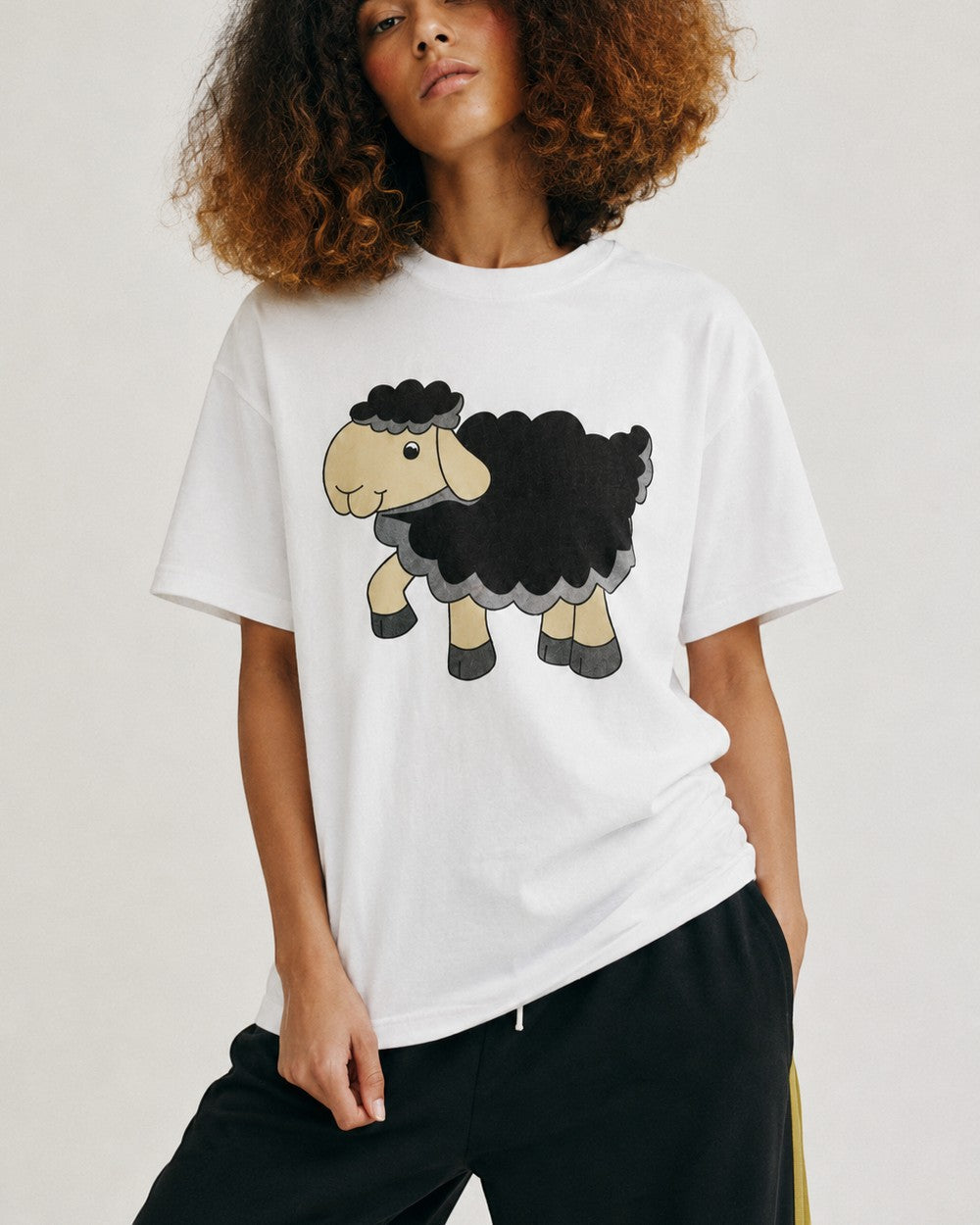 Femeie purtând tricou alb cu imprimeu simpatic cu oiță
